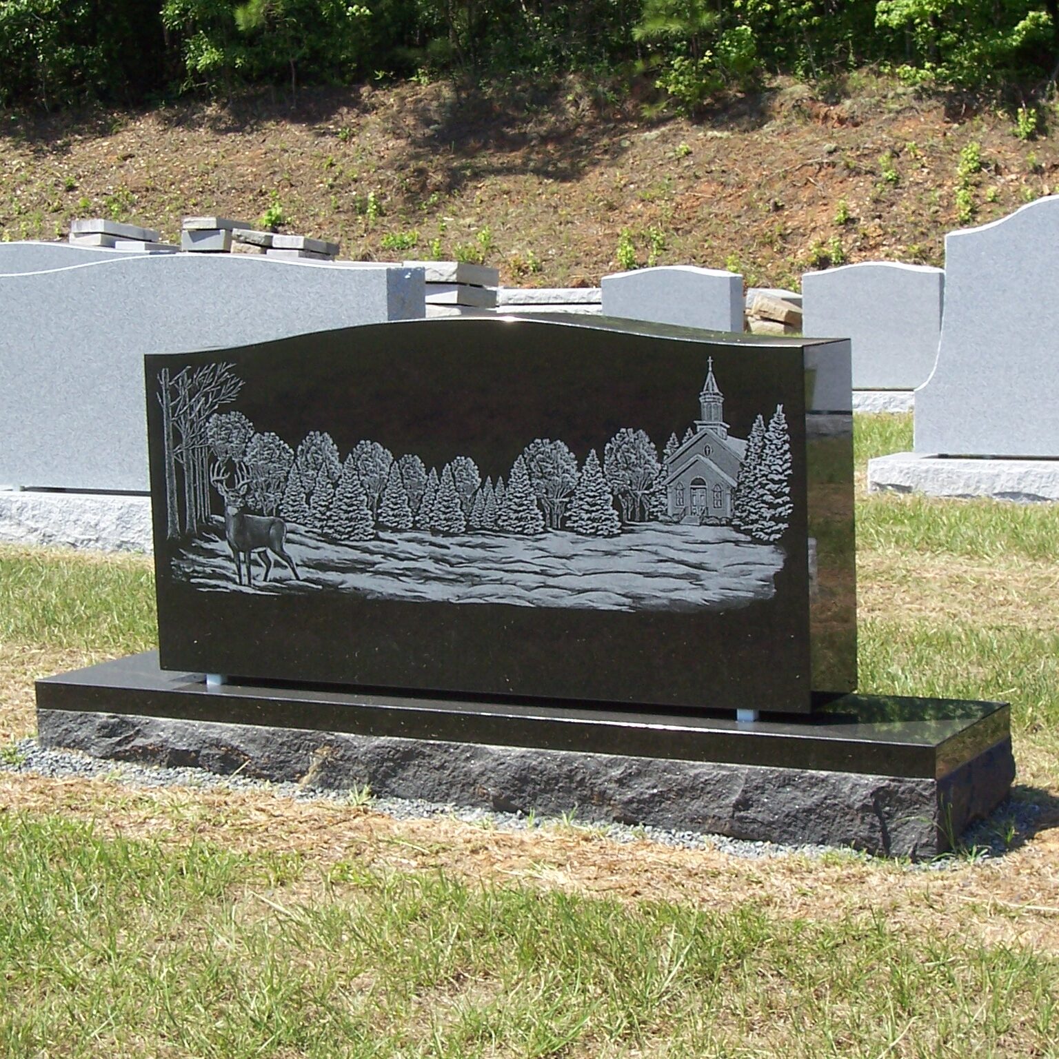 custom black granite headstone with engraving of forest scene