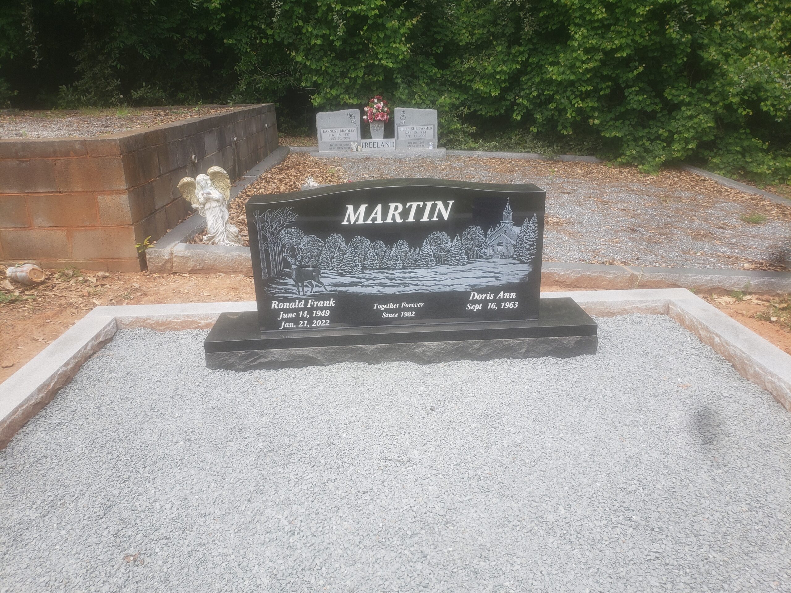 black granite companion monument with engraved forest scene